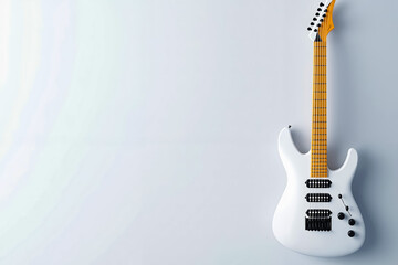 A white electric guitar hanging on a wall