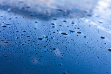 Water droplets accumulate on a blue surface after rainfall during the early morning hours