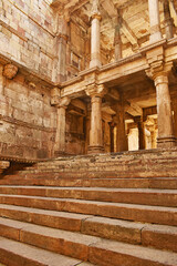 Interior view of Jethabhai's Stepwell (Jethabhai ni Vav), showcasing intricate 18th-century stone carvings on columns and stairs, found in Isanpur, Ahmedabad, Gujarat, India.