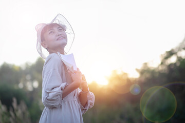Happy woman lying on green grass reading a book in the park (outdoors)
