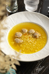 Portion of appetizing meatballs soup with star macaroni