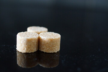 Brown sugar cubes shimmer under the light, revealing their perfect cubic shapes and delicate crystals. 