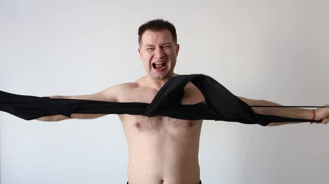 Strong man rips his shirt off