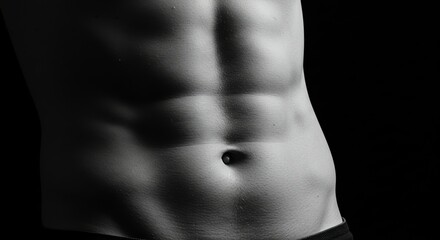 Fototapeta premium Showing Defined Abdominal Muscles Against a Dark Background