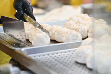 The photo shows the transition from sizzling griddle to serving tray, emphasizing the contrast between the high-heat cooking and clean metal surface.