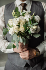 Wedding day. Groom holding a beautiful bouquet