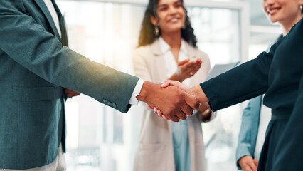Business people, handshake and meeting with partnership for b2b, deal or agreement at office. Group, employees or colleagues shaking hands with team for introduction, greeting or career opportunity © FremtonClay/peopleimages.com