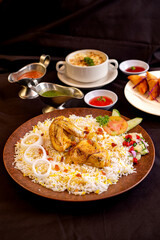 biryani and smoked barbeque chicken served on brown plate with pickles, tomato, cucumber and onion. Perfect for menu, advertising or commercial use