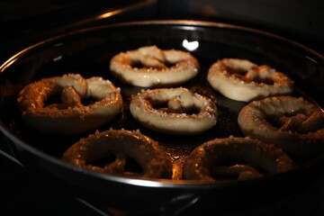 Baking dish with pretzels in oven, closeup