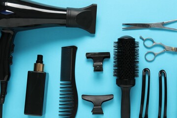 Different hairstyling tools on light blue background, flat lay