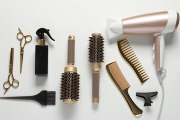 Different hairstyling tools on white background, flat lay