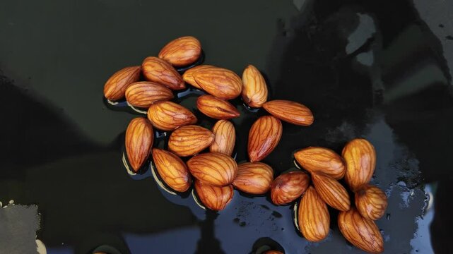 Almonds on water with dark background , slow motion