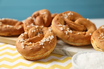 Tasty pretzels with salt on table, closeup