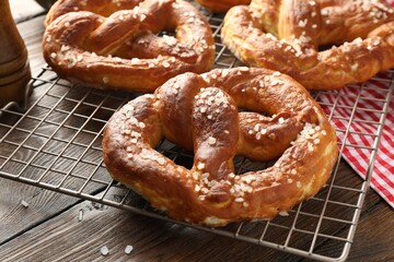 Tasty pretzels with salt on wooden table, closeup