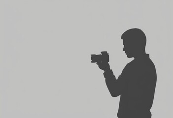 Man holding camera in profile silhouette against gray background