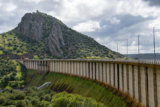 Alange, Spain. 04-27-25. Alange dam with a mountain behind.  A concrete gravity dam built on the Matachel River, a tributary of the Guadiana River. 