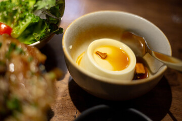 A sweet pudding to finish the meal served with a fresh vegetable salad and a bowl of grilled pork over rice