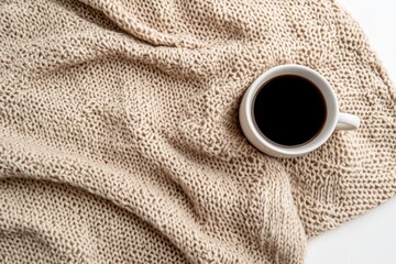 Cozy coffee on a beige knitted throw