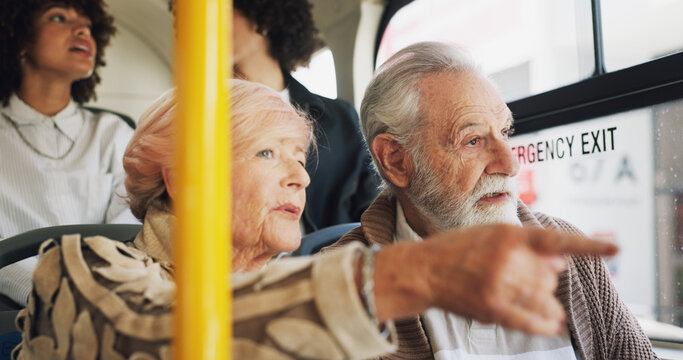 Old couple, travel and talking on bus ride to destination for public transport, holiday or vacation. People, pointing or elderly tourists by window in city for relationship, retirement or adventure - Powered by Adobe