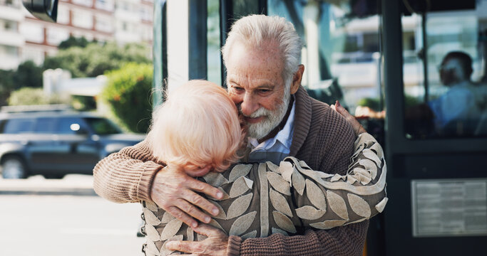 Senior couple, hug and travel in city for greeting, reunion and journey for visit at bus stop. Elderly people, passenger and embrace for commute of public transport, parting gesture and farewell trip - Powered by Adobe