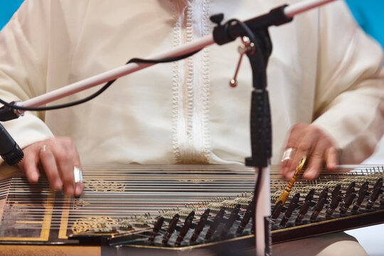 Traditional folk moroccan musician with wooden string instrument. Qanun