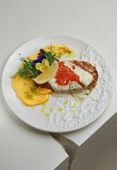 Plate of lobster with greens and purple flowers
