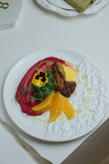 Plated dish with beetroot, citrus and greens