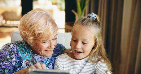 Bonding, family or tablet with grandmother and grandchild on sofa in living room of retirement home...