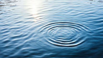 Naklejka premium Calm water surface with ripples expanding from central point, reflecting light beautifully
