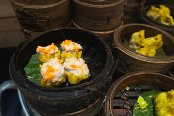 Various dimsum or dumplings menus in bamboo steamers piled up in Chinese restaurants.