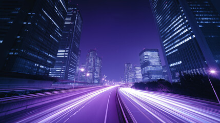 Obraz premium 夜の高層ビル街を駆け抜ける紫色の光の軌跡と高速道路
