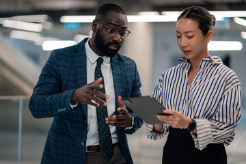 Businesspeople discussing work using tablet in office building