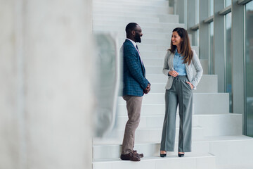 Businesspeople talking on stairs in modern office building