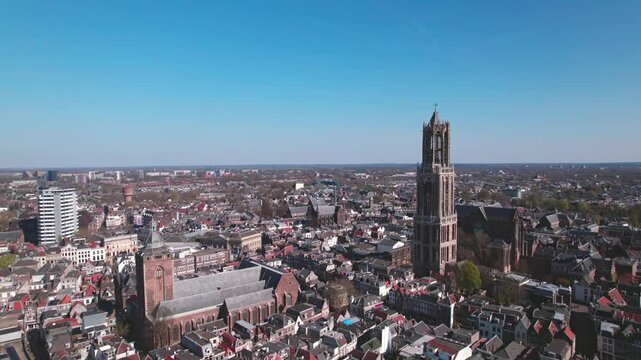 Cityscape aerial of city center Utrecht, The Netherlands, on a bright sunny day with church and cathedral rising above the low build picturesque canal homes. Urban development and Dutch flat landscape