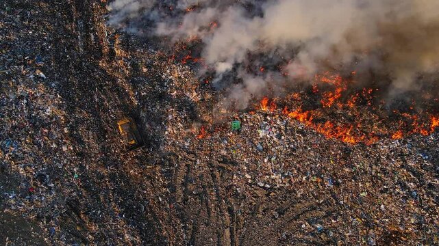 Aerial view of landfill engulfed in fire and covered in dense smoke