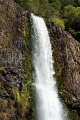 Fototapeta premium Close-up view of Hunua Falls cascading over rocky cliff