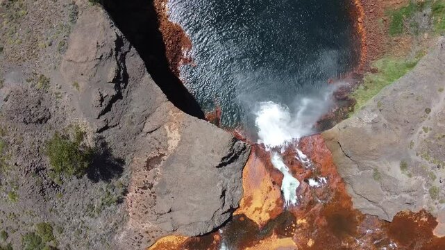 amazing waterfall with orange and blue colors as the acid water flows in Salto del Agrio in Argentina