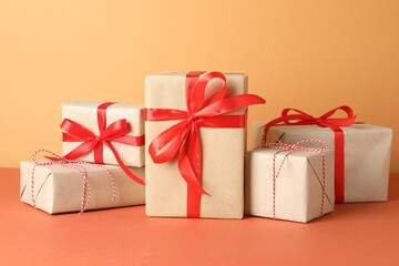 Many gift boxes wrapped in kraft paper on orange table