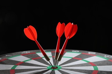 Targeting. Dart board with arrows on black background, closeup