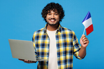 Young smiling smart IT Indian man wear yellow checkered shirt casual clothes hold French flag use...