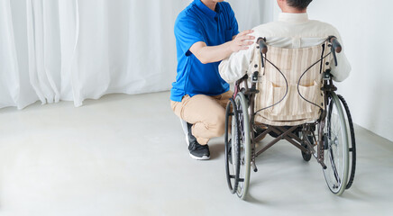 Obraz premium 男性介護士と車椅子に乗った高齢者男性