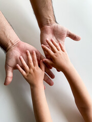 Adult and child hands reaching across white background