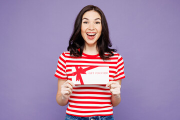 Young shocked woman she wear red striped t-shirt casual clothes hold gift certificate coupon...