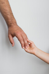 Adult male hand holding child hand symbolizing trust and connection