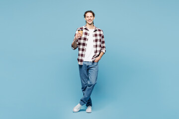 Fototapeta premium Full body young man wear purple checkered shirt casual clothes hold takeaway delivery craft paper brown cup coffee to go isolated on plain pastel light blue cyan background studio. Lifestyle concept.