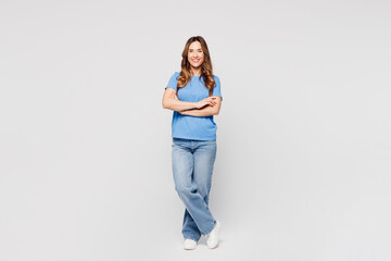 Full body young smiling happy cheerful woman wears blue t-shirt casual clothes hold hands crossed folded look camera isolated on plain solid white color background studio portrait. Lifestyle concept. © ViDi Studio