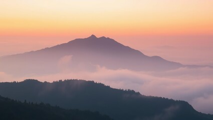 Majestic mountain range at sunset with soft hues and floating clouds