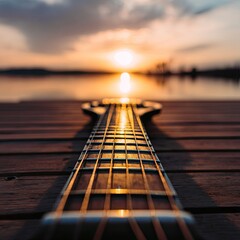 Acoustic guitar neck at sunset over water