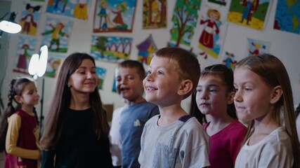 Joyful children singing in chorus in elementary school class - Powered by Adobe