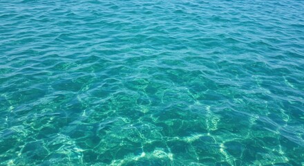 Obraz premium Clear turquoise ocean water with gentle ripples reflecting sunlight